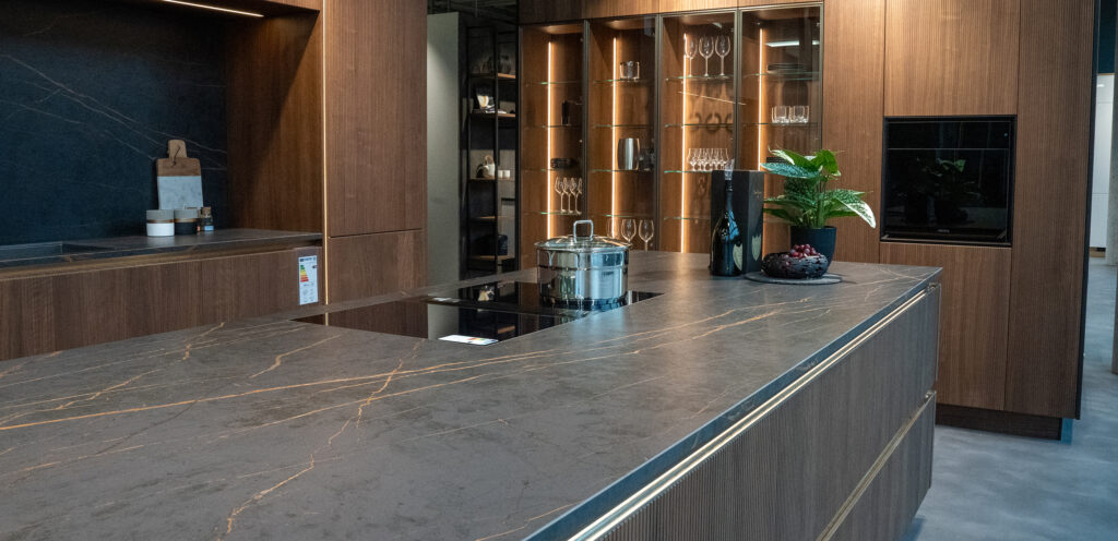 Großzügige Inselküche mit Granitarbeitsplatte und Holzfronten mit Vitrine