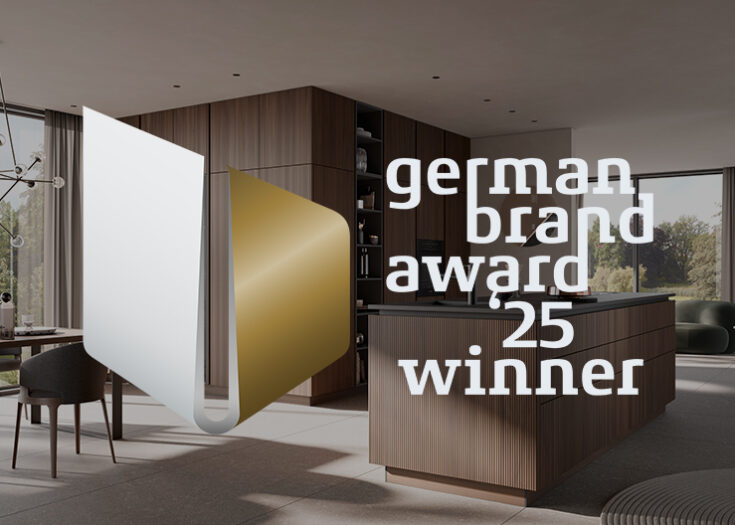 German Brand Award '25 Winner Auszeichnung vor dem Hintergrund einer stilvollen, modernen Küche mit Holzfronten und Kochinsel.